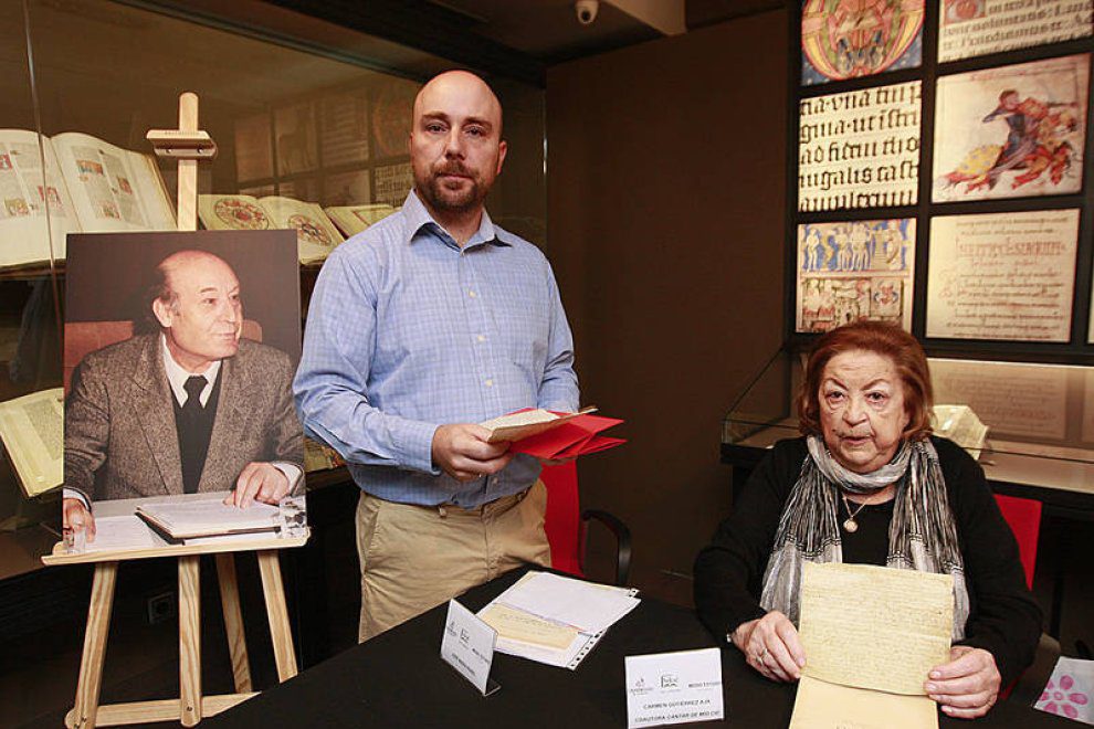 Presentación del libro: M.ª del Carmen Gutiérrez Aja sostiene uno de los documentos facsímiles, junto a un retrato de Timoteo Riaño colocado sobre un caballete